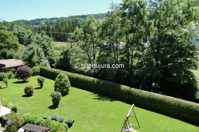 Vue dégagée sur le jardin arboré et la montagne